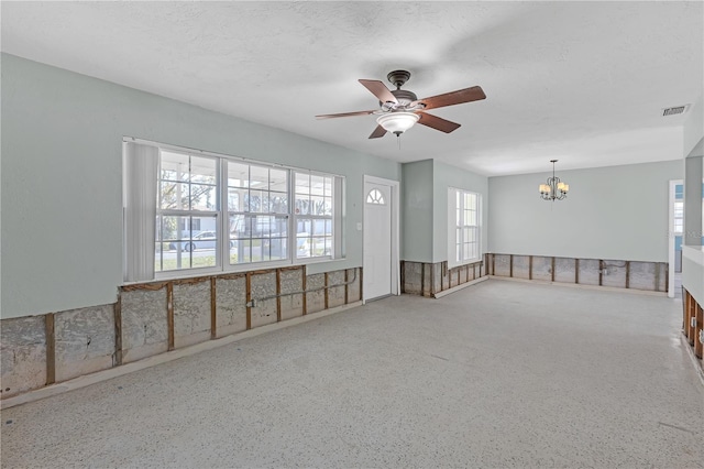 unfurnished room with visible vents, speckled floor, a textured ceiling, and ceiling fan with notable chandelier