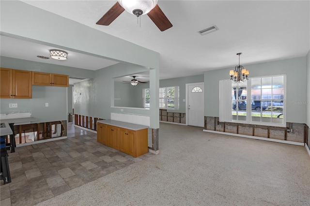 kitchen featuring ceiling fan with notable chandelier, visible vents, open floor plan, light countertops, and hanging light fixtures