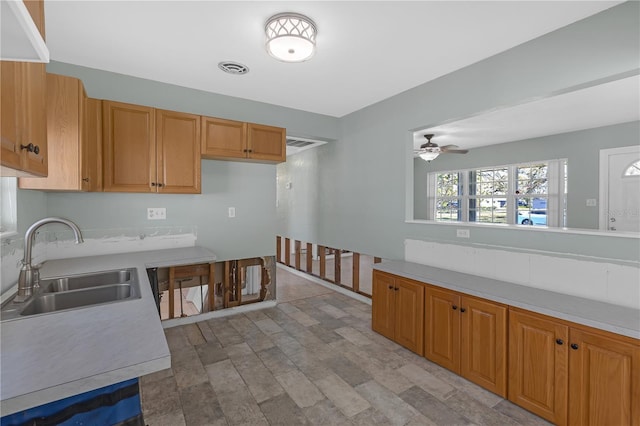 kitchen with light countertops, a sink, and ceiling fan