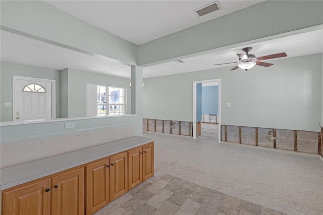 unfurnished room with light carpet, visible vents, and a ceiling fan