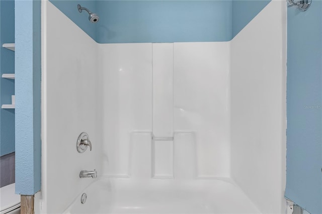 bathroom with baseboard heating and shower / bathtub combination