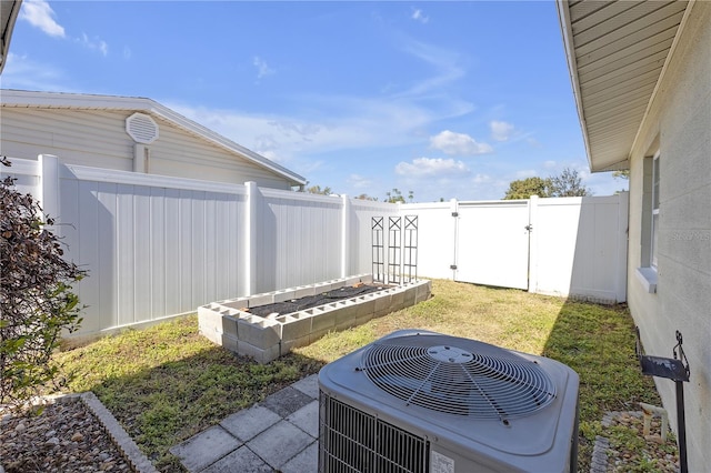 view of yard with cooling unit, a gate, and a fenced backyard