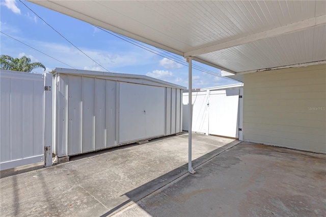 view of patio featuring a storage shed, a gate, and fence