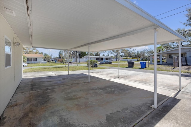 view of vehicle parking featuring a carport and a residential view