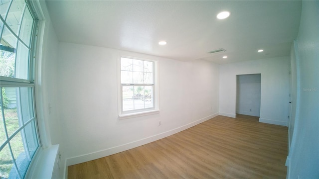 spare room with baseboards, wood finished floors, visible vents, and recessed lighting