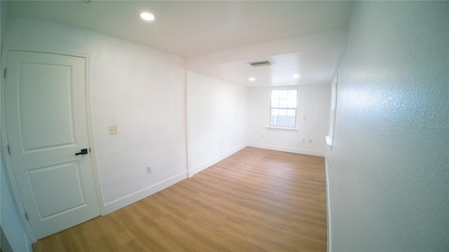 empty room featuring recessed lighting, wood finished floors, visible vents, and baseboards