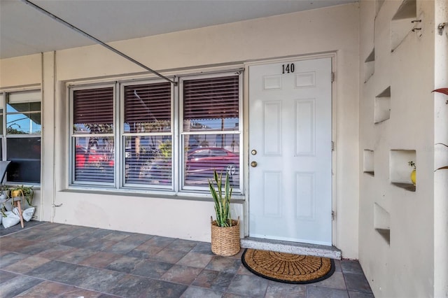 doorway to property featuring stucco siding