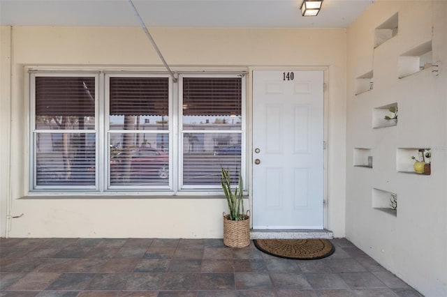 view of exterior entry with stucco siding