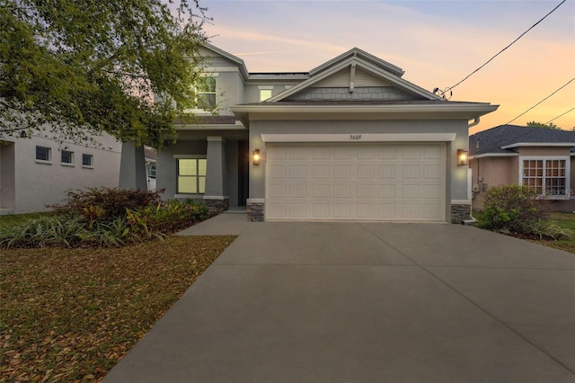 craftsman inspired home with a garage, stone siding, concrete driveway, and stucco siding