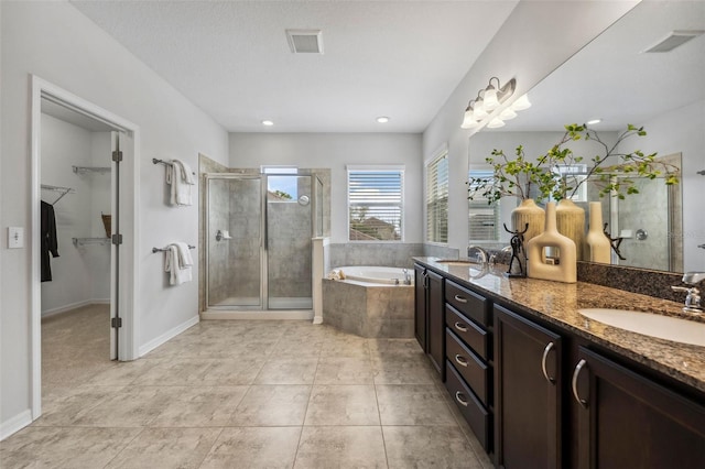 full bathroom with a stall shower, visible vents, a sink, and a garden tub