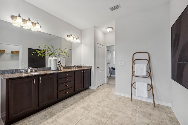 full bathroom featuring double vanity, a sink, visible vents, and baseboards