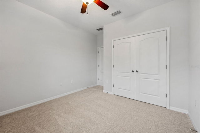 unfurnished bedroom with light carpet, baseboards, visible vents, and a closet