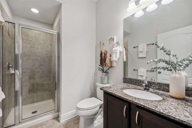 full bath featuring toilet, vanity, a shower stall, baseboards, and tile patterned floors