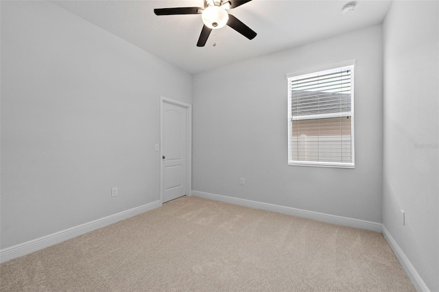 unfurnished room featuring light colored carpet, ceiling fan, and baseboards