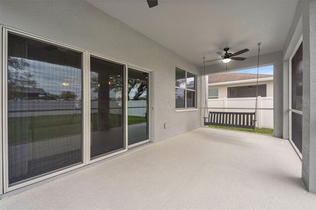 view of patio with ceiling fan and fence