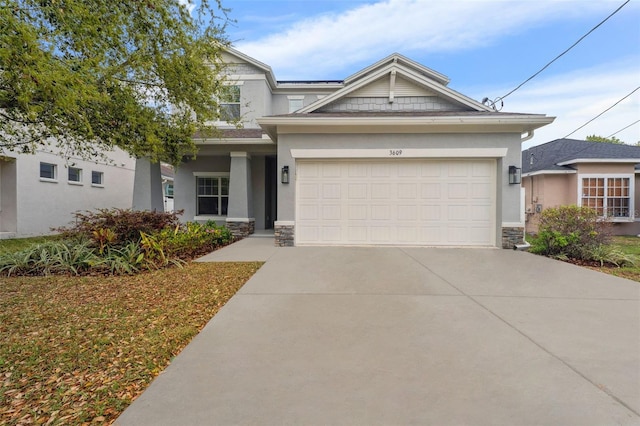 view of front facade with stone siding, an attached garage, concrete driveway, and stucco siding