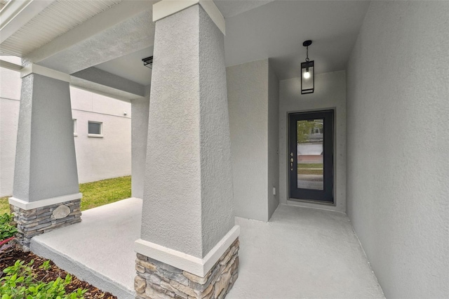 property entrance featuring stone siding and stucco siding