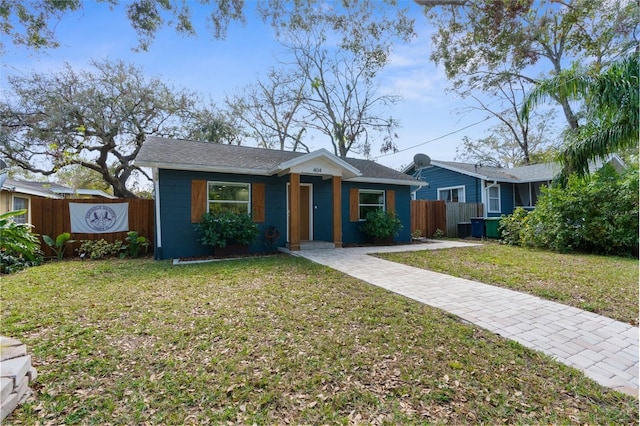 bungalow with fence and a front lawn