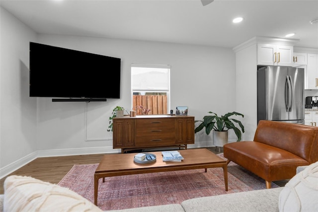 living room with recessed lighting, baseboards, and wood finished floors