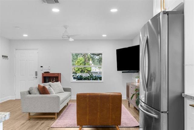 living room featuring light wood-style floors, baseboards, and recessed lighting