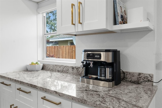 interior space with white cabinetry and light stone countertops