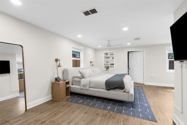 bedroom with baseboards, visible vents, wood finished floors, and recessed lighting