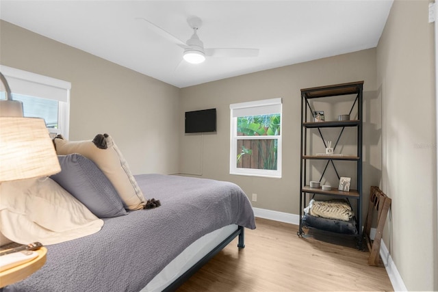 bedroom featuring baseboards, ceiling fan, and light wood finished floors