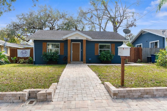 bungalow-style home featuring fence and a front lawn