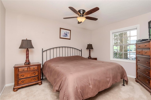 bedroom with baseboards, a ceiling fan, and light colored carpet