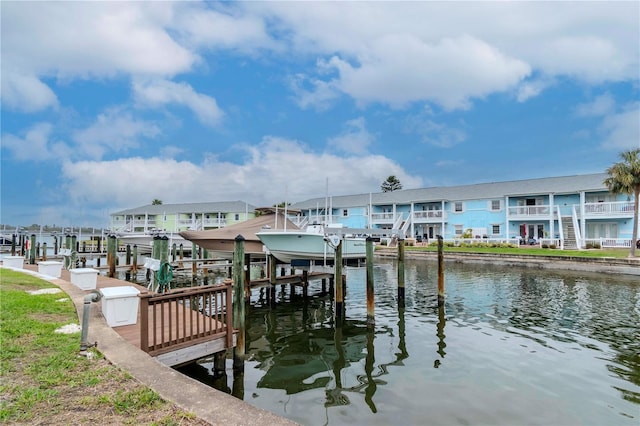 dock area with a water view, boat lift, and a residential view