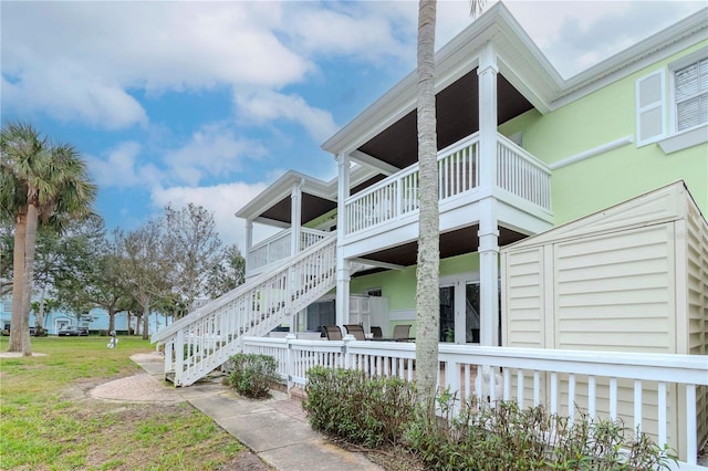 view of side of home with a yard and stairway