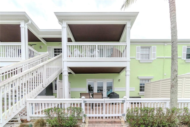 exterior space with french doors, stairway, and stucco siding