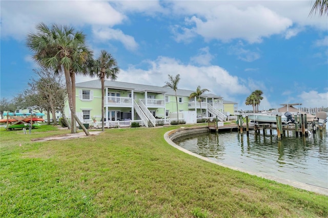 view of dock with a water view, boat lift, and a yard