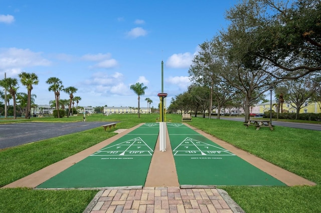 view of community with a yard and shuffleboard