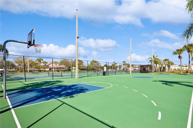 view of basketball court with community basketball court, a tennis court, and fence