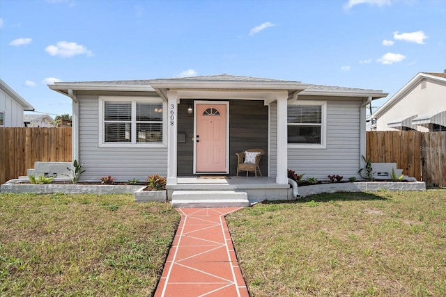 bungalow featuring fence and a front lawn