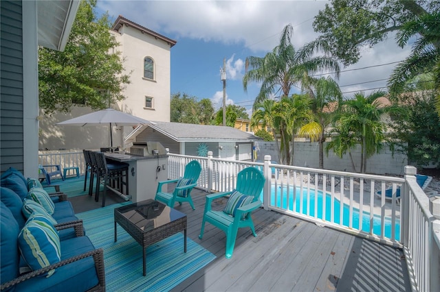 wooden deck featuring a fenced in pool, a fenced backyard, outdoor dry bar, and an outdoor hangout area