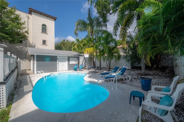 view of swimming pool featuring a fenced in pool, a fenced backyard, and a patio