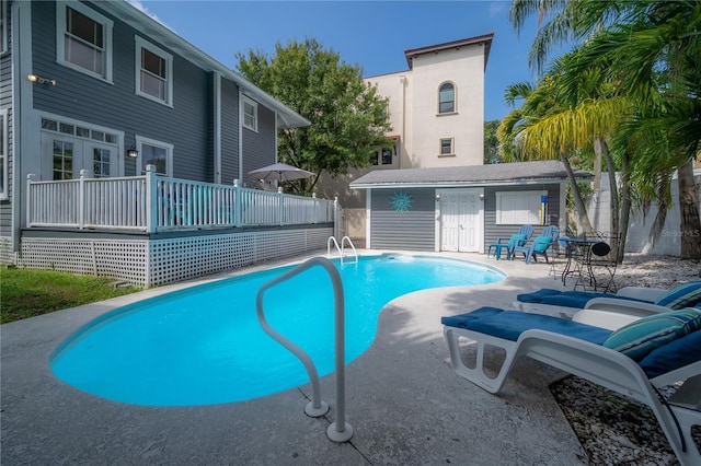 view of pool featuring a fenced in pool, a patio, fence, an outdoor structure, and a wooden deck