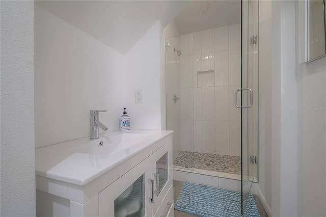 full bath featuring a shower stall, vaulted ceiling, and a sink