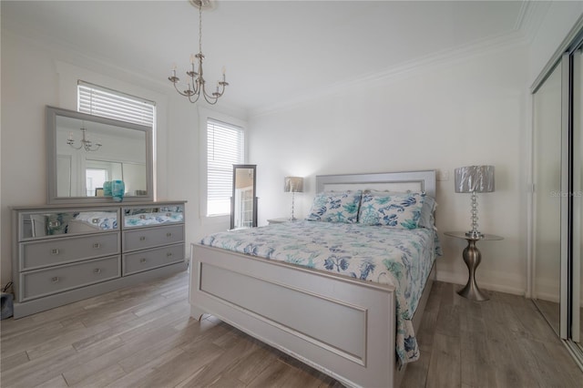 bedroom with crown molding, a notable chandelier, and wood finished floors