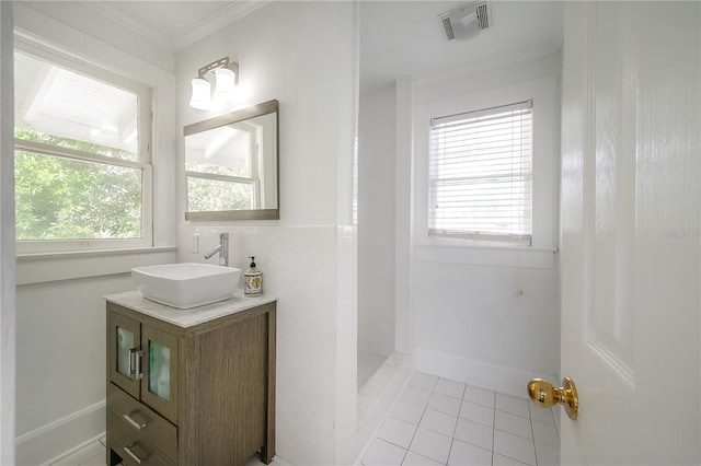 full bathroom featuring visible vents, ornamental molding, vanity, tiled shower, and tile patterned floors
