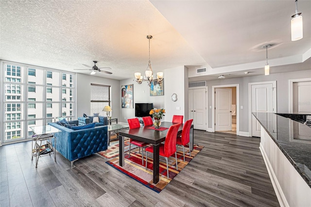 dining space with baseboards, visible vents, dark wood finished floors, a wall of windows, and a textured ceiling