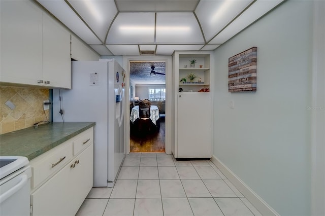 131 Bluff View Dr Unit 208, Belleair Bluffs, FL 33770 - kitchen featuring stove, dark countertops, decorative backsplash, white cabinets, and white fridge with ice dispenser