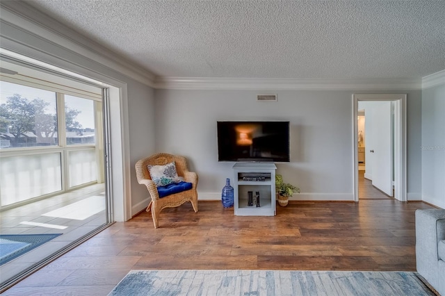 131 Bluff View Dr Unit 208, Belleair Bluffs, FL 33770 - sitting room with a textured ceiling, crown molding, and wood-type flooring
