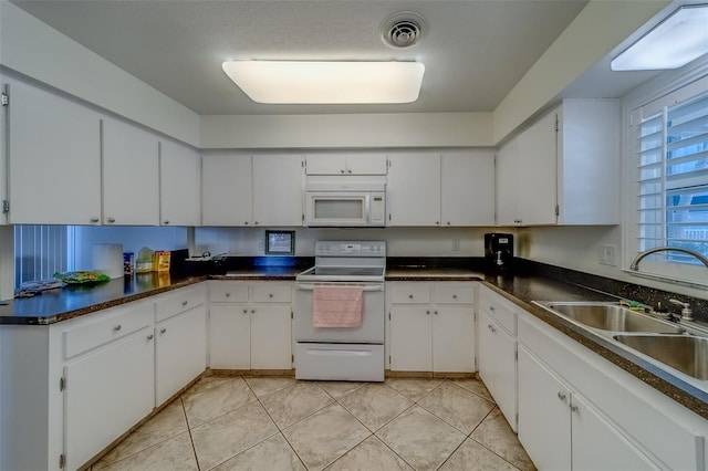 131 Bluff View Dr Unit 208, Belleair Bluffs, FL 33770 - kitchen featuring white appliances, white cabinetry, and dark countertops