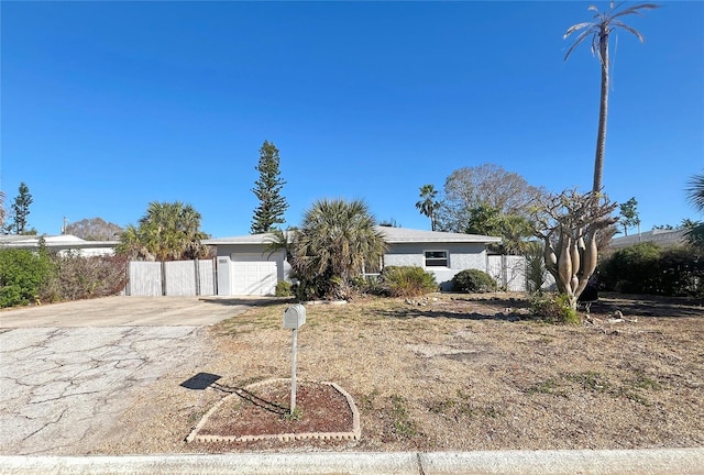 ranch-style house featuring concrete driveway and an attached garage