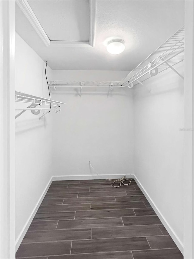 spacious closet featuring wood tiled floor and attic access