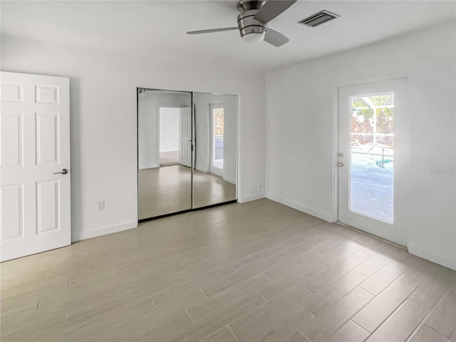 unfurnished bedroom featuring baseboards, light wood finished floors, visible vents, and a ceiling fan