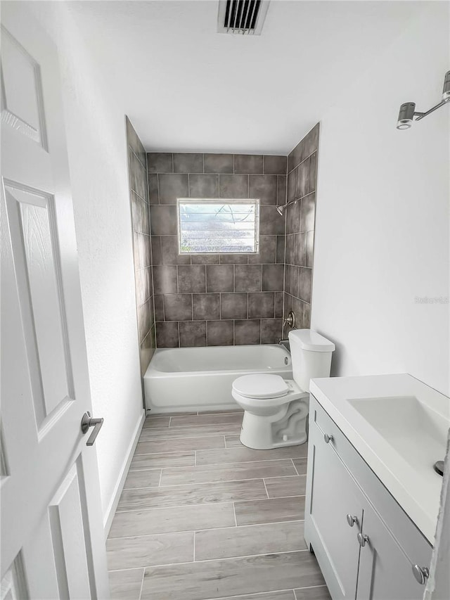 full bathroom featuring visible vents, toilet, shower / bathtub combination, wood tiled floor, and vanity